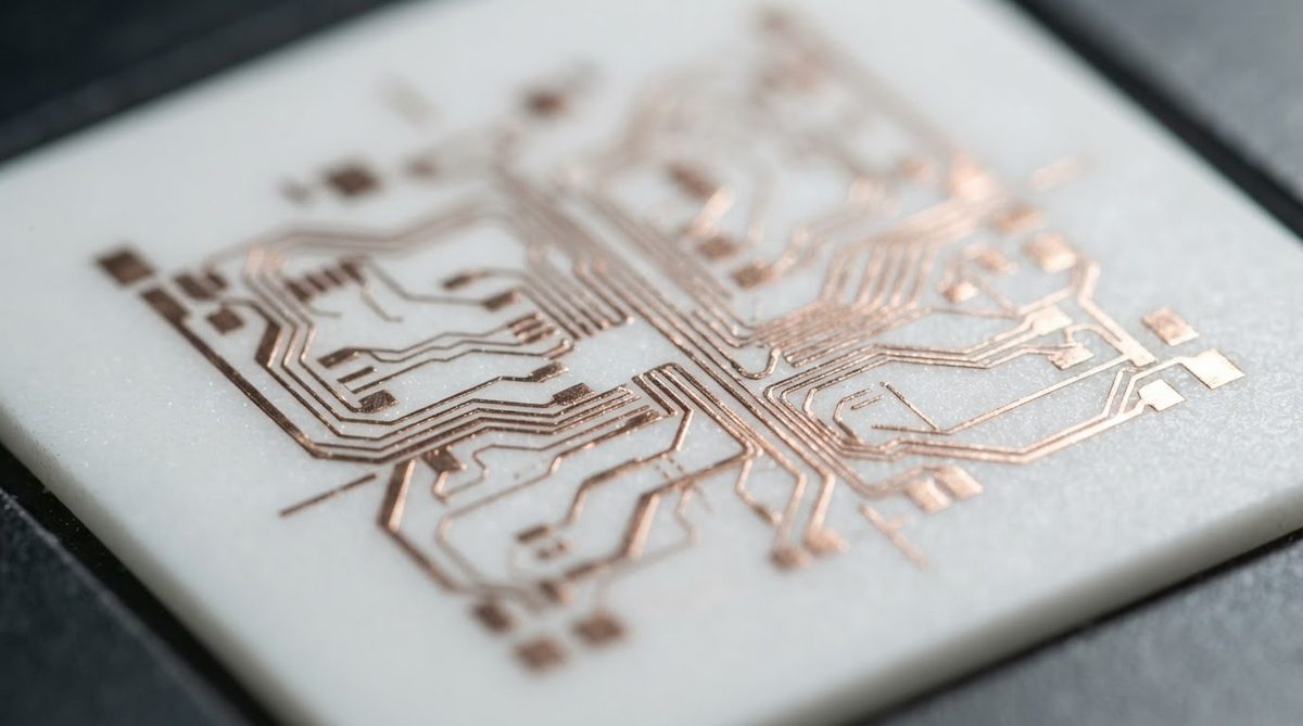 Thin-film copper traces on a polished alumina substrate viewed under magnification