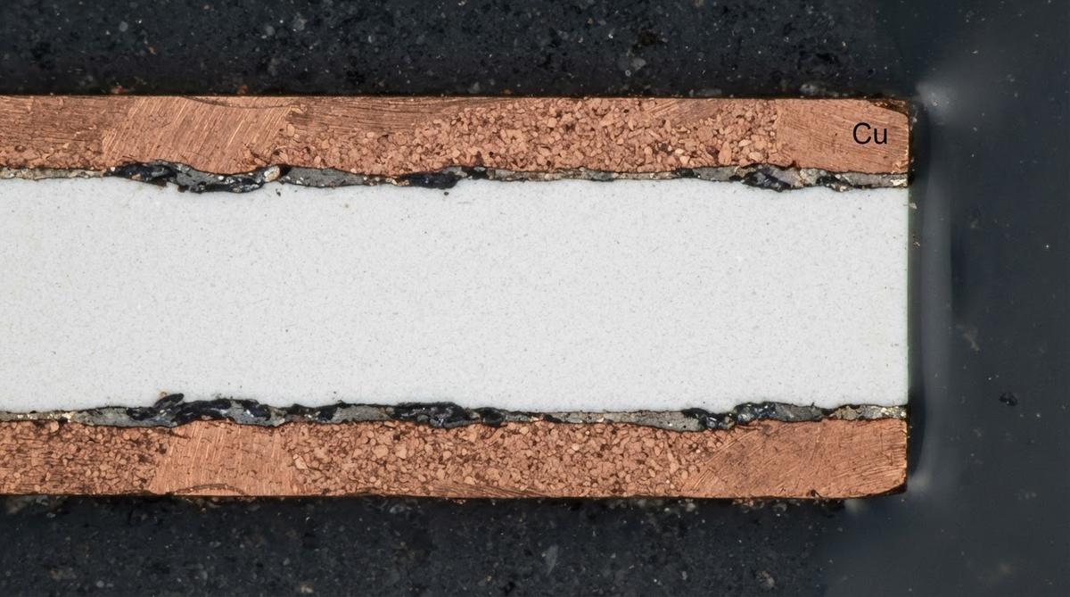 Cross-section of a DBC substrate showing copper and ceramic layers under magnification