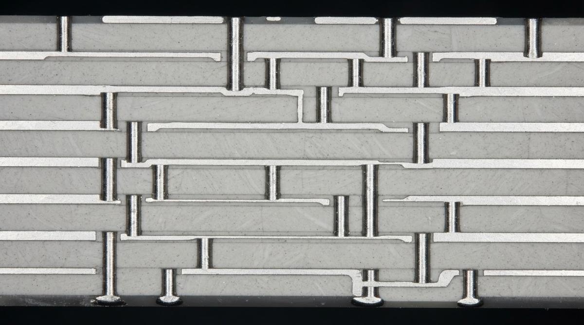 Microscope cross-section of a multilayer LTCC substrate showing internal conductors and vias