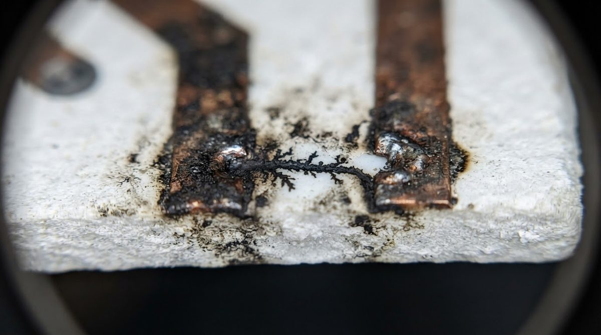Surface flashover damage between traces on a ceramic PCB after hipot failure