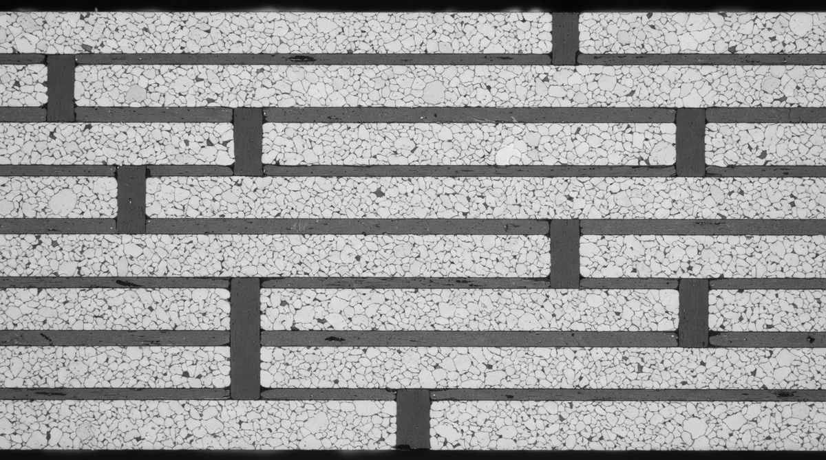 Polished cross-section of a fired HTCC substrate revealing embedded tungsten conductors