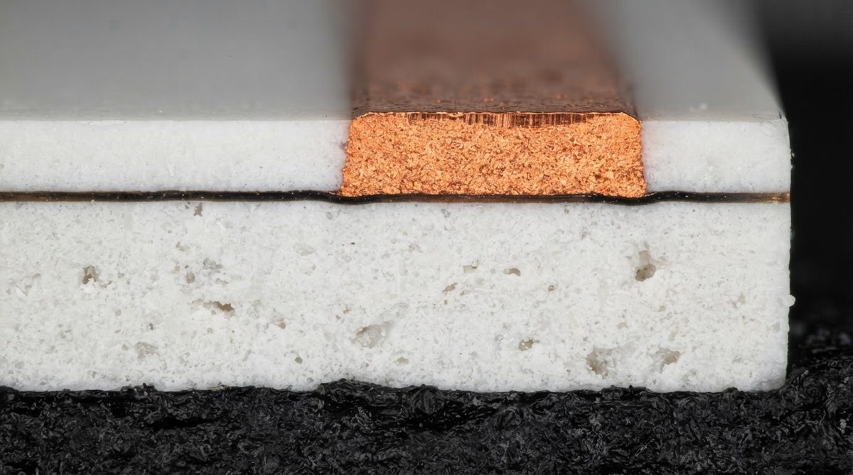 Cross-section of ceramic PCB metallization showing copper and adhesion layers on alumina
