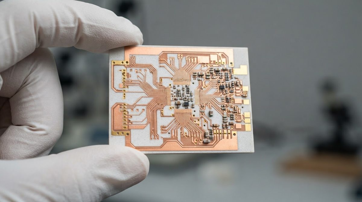 Finished Si3N4 AMB substrate with copper traces held by gloved hand